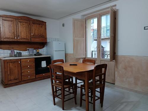 cocina con mesa de madera y sillas en Casetta nel Borgo Pianello con vista panoramica, en Muro Lucano