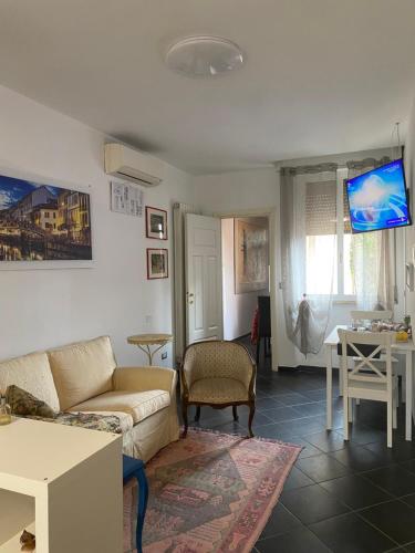 salon z kanapą i telewizorem w obiekcie Al 20 Guest House Fiera Milano - Certosa - San Siro w Mediolanie