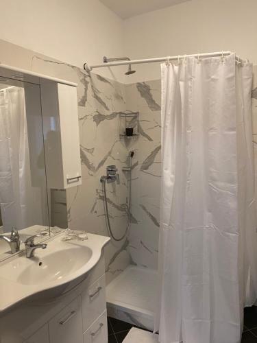 a bathroom with a shower curtain and a sink at Al 20 Guest House Fiera Milano - Certosa - San Siro in Milan
