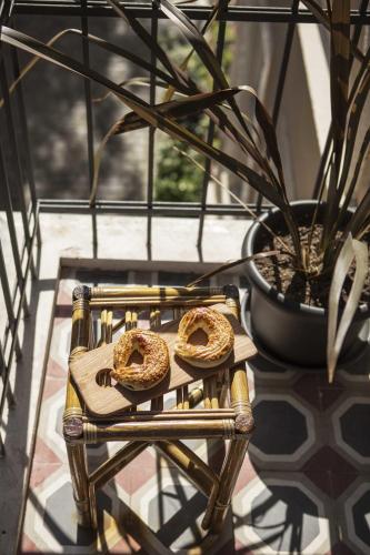 two bagels sitting on a cutting board next to a potted plant at Kumbaracı Apartments & Suites in Istanbul