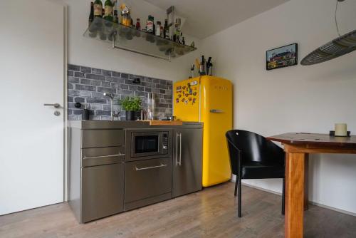 a kitchen with a yellow refrigerator and a table at Apartment Mini-Loft am Schloss in Raesfeld