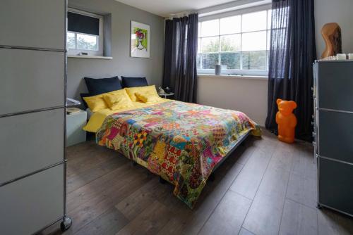 um quarto com uma cama com uma colcha colorida e uma janela em Apartment Mini-Loft am Schloss em Raesfeld
