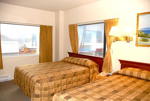 a hotel room with two beds and two windows at Hotel Deoro in Lillooet
