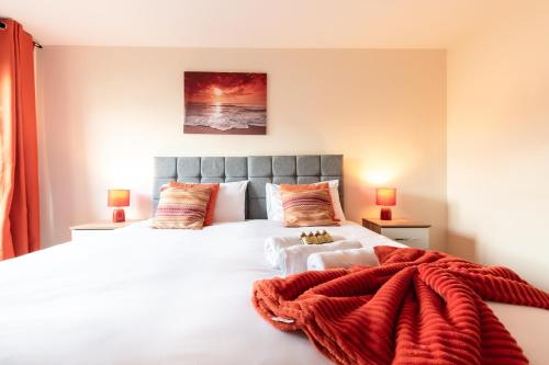 een slaapkamer met een groot bed en een rode deken bij BEST PRICE! STUNNING 2 Bed City Centre - 4 single beds or 2 Super king, Smart TVs, Sofa Bed & FREE SECURE PARKING in Southampton