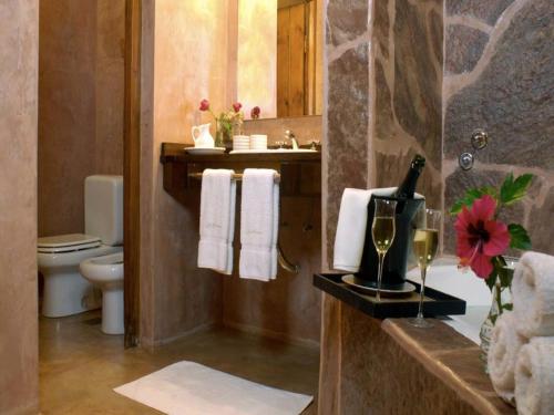 a bathroom with a toilet and a sink with a bottle of champagne at Los Brunos Posada in Reconquista