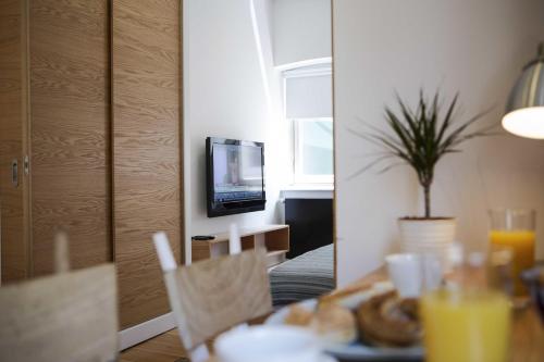 a table with a plate of food and a television at Kumbaracı Apartments & Suites in Istanbul