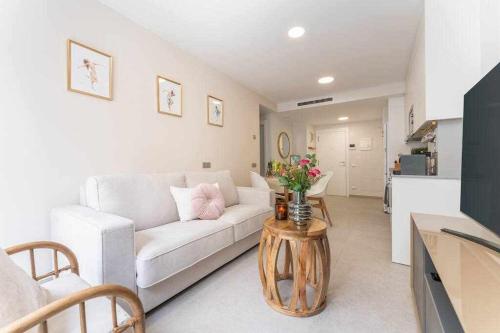 sala de estar con sofá blanco y mesa con flores en Moderno piso en Las Palmas de Gran Canaria, en Las Palmas de Gran Canaria