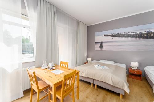 a bedroom with a table and a bed and a table and chairs at Ośrodek Wypoczynkowy Wiga in Kołobrzeg