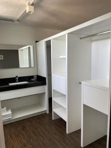 a white bathroom with a sink and a mirror at Vintage Lofts in Guadalajara