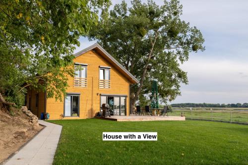 a yellow house with a view of a yard at Houses with a View#Sauna#Jaccuzi in Gozdowice