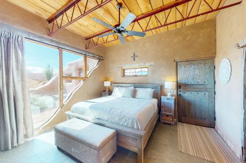 a bedroom with a bed and a large window at Casa de Taos in Arroyo Hondo
