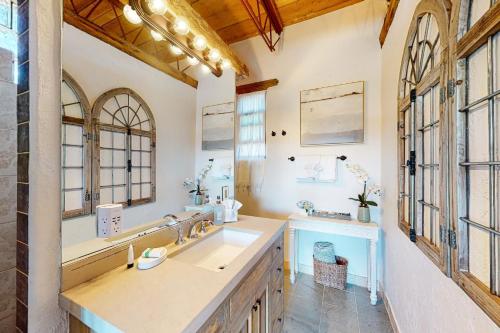 baño con lavabo y espejo grande en Casa de Taos, en Arroyo Hondo