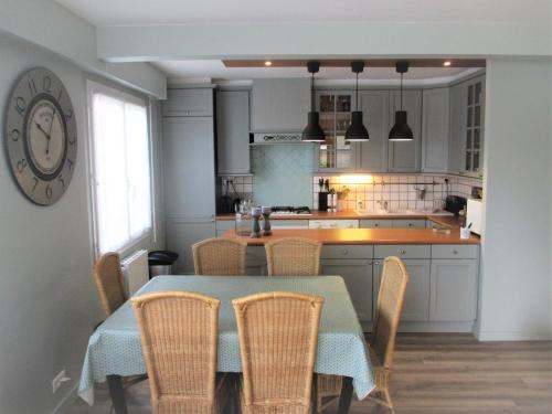 une cuisine avec une table et des chaises et une cuisine avec un comptoir dans l'établissement Le Touquet quartier Atlantique T4 vue mer, à Le Touquet-Paris-Plage