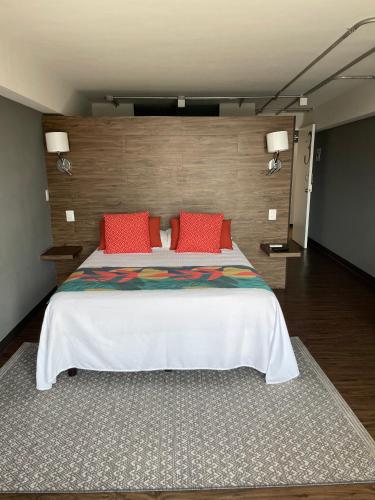 a bedroom with a large bed with red pillows at Vintage Lofts in Guadalajara