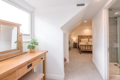 a bathroom with a sink and a mirror and a bedroom at Coasters, Aldeburgh in Aldeburgh