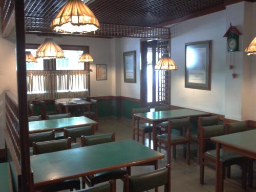 ein Esszimmer mit Tischen, Stühlen und Lichtern in der Unterkunft Hotel Cielo Azul in Mar del Plata