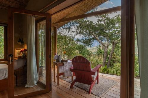 - une chambre avec une table et une chaise sur une terrasse couverte dans l'établissement Gocta Natura Reserve, à Cocachimba