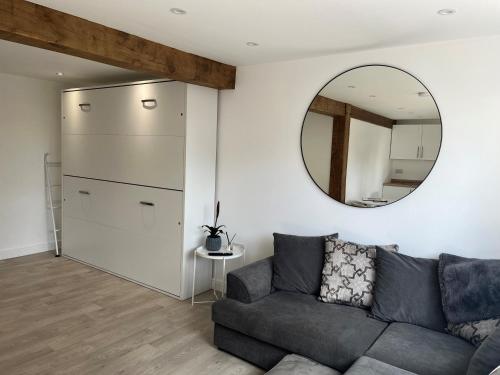 un soggiorno con un divano e uno specchio di Acorn Lodge a Eastergate