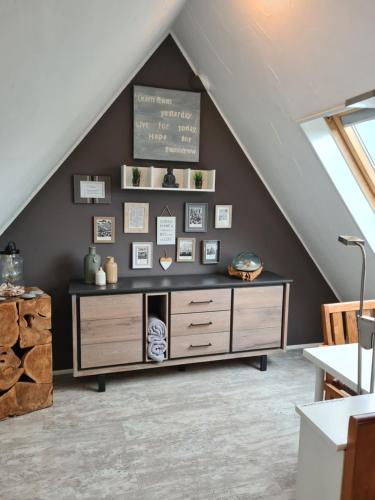 a living room with a dresser in a attic at Stylisches Garden Cottage in Weyhe