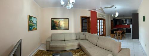 a living room with a couch and a kitchen at Shtepi Me qera Fier in Fier