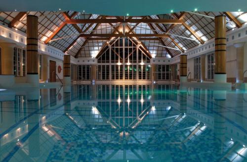 a large swimming pool in a building at Champneys Forest Mere in Liphook