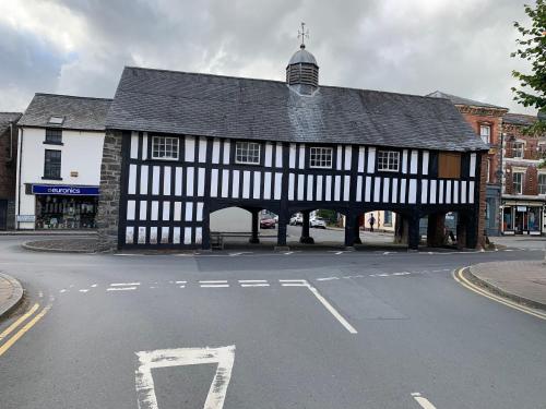 an old black and white building on a street at Llanidloes Townhouse-pet-friendly-sleeps 7-Mid Wales in Llanidloes