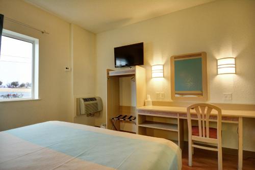 a bedroom with a bed and a desk and a television at Motel 6-Denison, TX in Denison