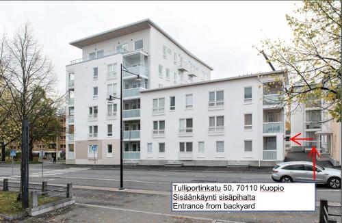 ein weißes Gebäude mit einem Schild davor in der Unterkunft City Home Aapeli in Kuopio