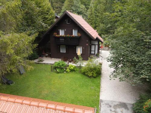 a small house with a balcony with flowers on it at Chalet Lana with Hot Tub in Gozd Martuljek