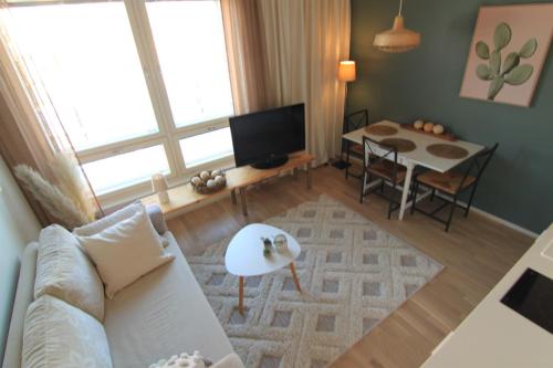 a living room with a couch and a table at City Home Aapeli in Kuopio