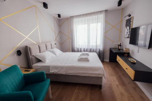 a bedroom with a bed and a chair and a television at La Casa 2 in Vršac