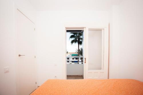 ein weißes Zimmer mit einem Bett und einem Fenster in der Unterkunft ESTUDIO EN JAVEA in Jávea