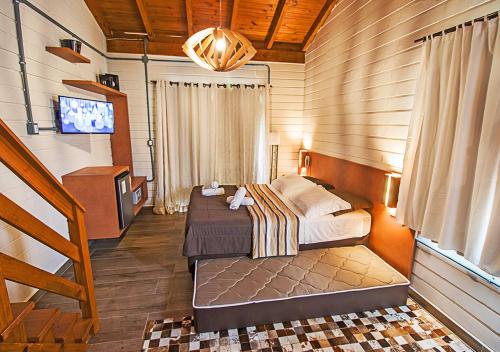 um quarto com duas camas e uma televisão em Hotel Acqua Lokos em Capão da Canoa