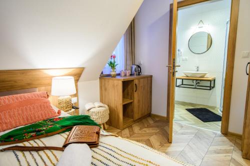 a bedroom with a king sized bed and a bathroom at Maryna Bór in Zakopane