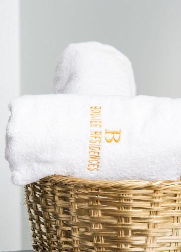 a basket with white towels and glasses on it at Boujee Residence Apartment in Kampala