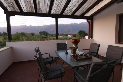 - Balcón con mesa y sillas y vistas a las montañas en A luxury mansion near Kerkini lake (Villa Oriana), en Kerkíni