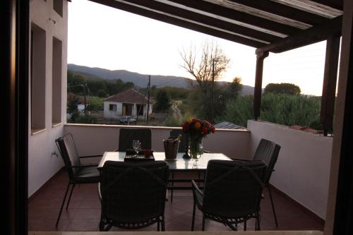 patio con mesa y sillas en el balcón en A luxury mansion near Kerkini lake (Villa Oriana), en Kerkíni
