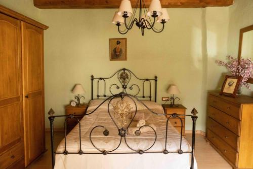 um quarto com uma cama e um lustre em MAS DE BONDIA - Casa Herrero em Alpuente