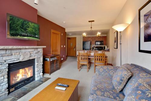 a living room with a couch and a fireplace at The Village Lodge in Mammoth Lakes