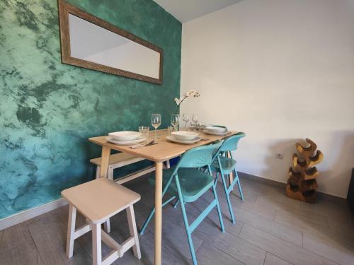 a dining room with a wooden table and chairs at Corralejo Happy Place, precioso apartamento con piscina in Corralejo