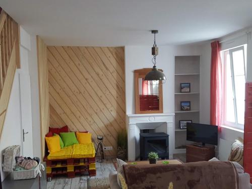 uma sala de estar com um sofá e uma lareira em La Belle Etaploise em Étaples