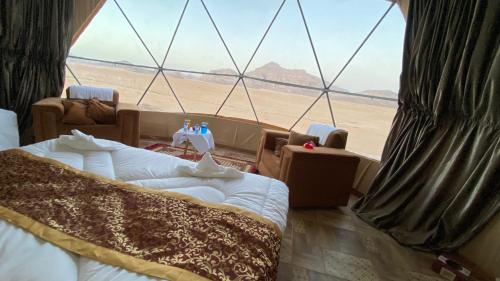 a room with two beds and a view of the desert at Warm bubbles Wadi Rum in Wadi Rum
