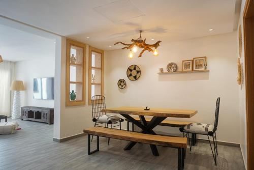 uma sala de jantar com uma mesa de madeira e cadeiras em Tililt By Mood 9 Px Luxe em Imsouane