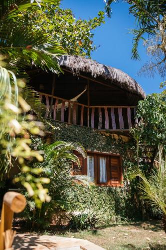 a building with a thatched roof with a tree at Hurricane Jeri in Jericoacoara