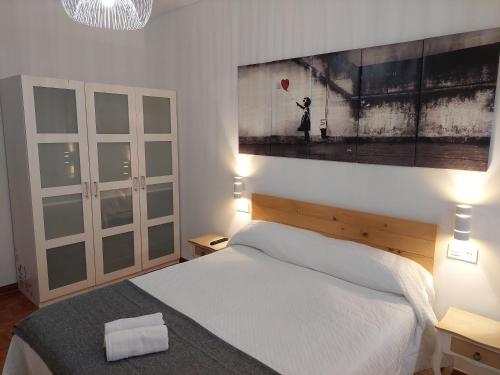 1 dormitorio con 1 cama y una pintura en la pared en Piso luminoso, amplio y tranquilo en Casco Viejo, en Bilbao