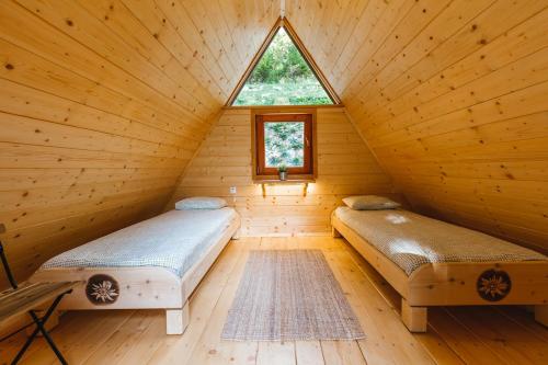 two beds in a log cabin with a window at Nature escape woodhouse in Žirovnica