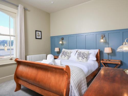 a bedroom with a bed and a chair and a window at Ferrystone in Dartmouth