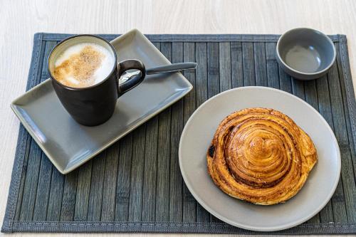a table with a cup of coffee and a pastry at Terre Etrusche Guest House-Terme -3 minuti da Viterbo centro in Viterbo