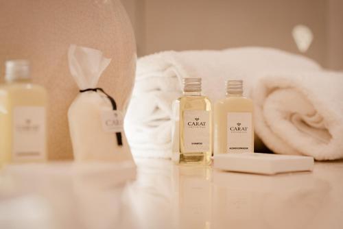 two bottles of soap on a counter with towels at Hotel Carat Apart Boutique in Rosario