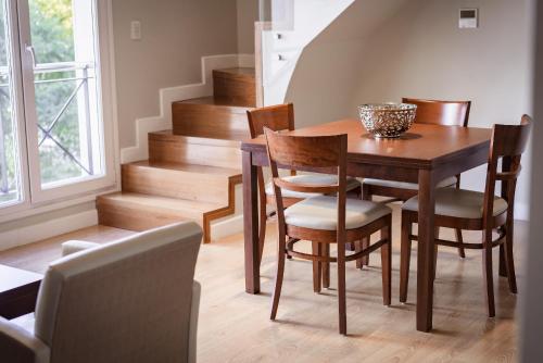 a dining room with a wooden table and chairs at Hotel Carat Apart Boutique in Rosario
